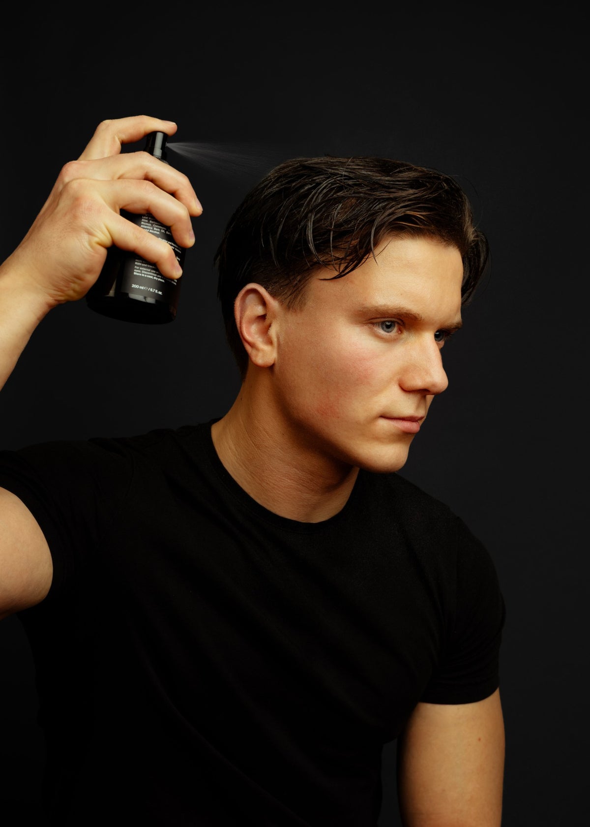 Mann sprüht das Sea Texture Spray ins Haar